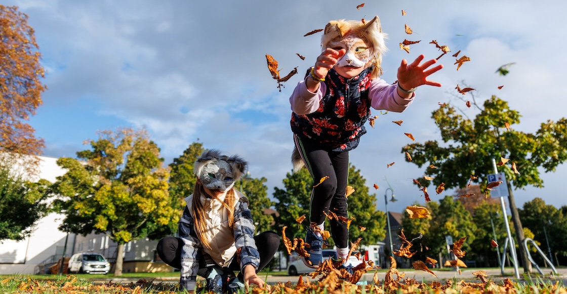 Cute young little kid girl wear cat furry mask enjoy have fun playing outdoors in forest street park. Children therian wild animal character trendy fan culture. Teenager social expression hobby